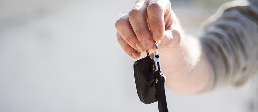 Mann hält Autoschlüssel für Carsharing bereit