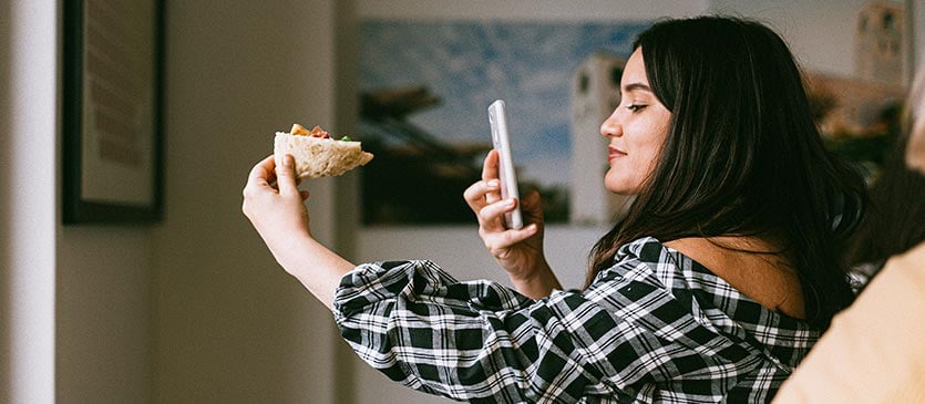 Influencerin fotografiert Essen fĂŒr Social-Media-KanĂ€le