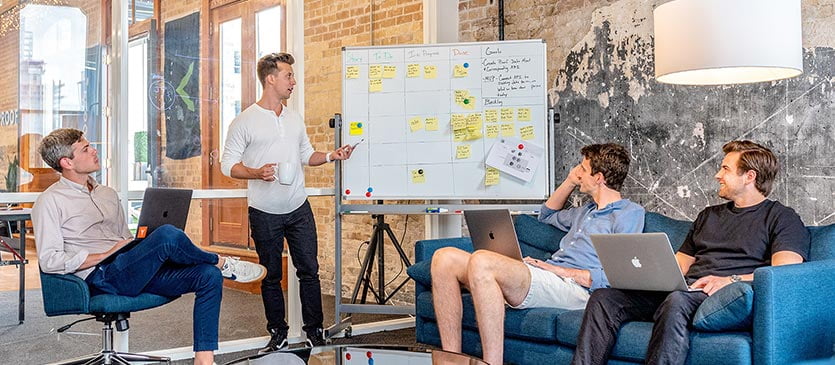 Praktikant zeigt mit Stift zum Whiteboard