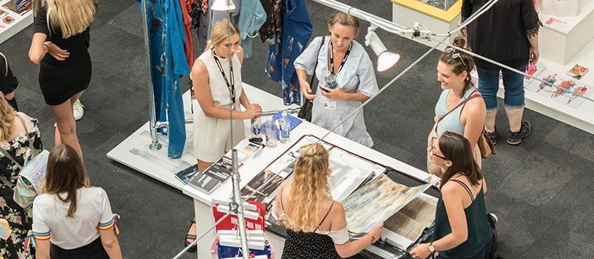 Junge Frau arbeitet als Promoterin an einem Messestand